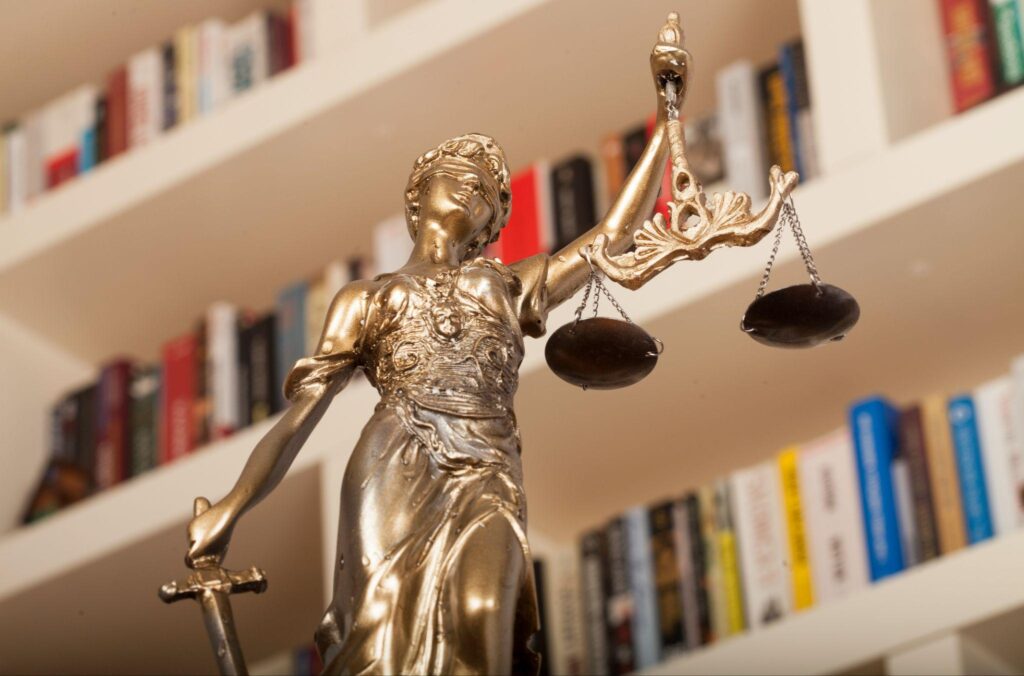 Statue of Justice against a backdrop of books on shelves