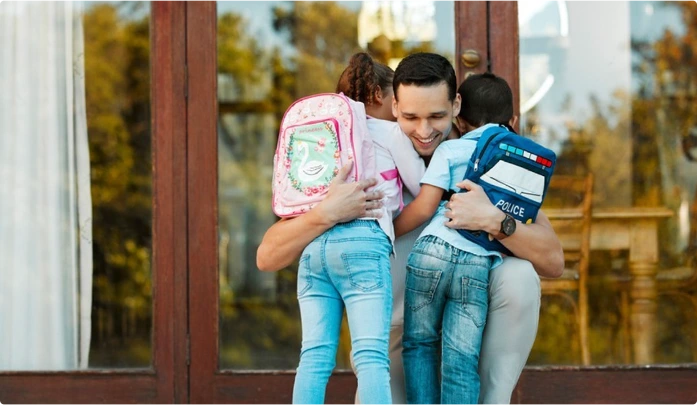 Parent hugging two small children